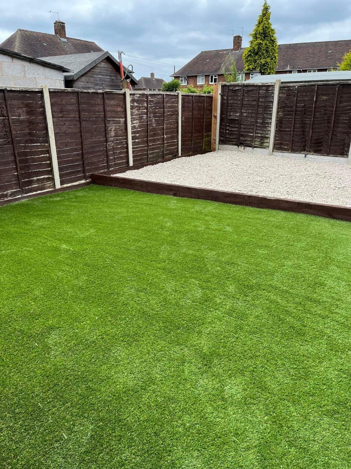 Artificial lawn with a sleeper-edged gravel area at the end of the garden and lap panel fencing