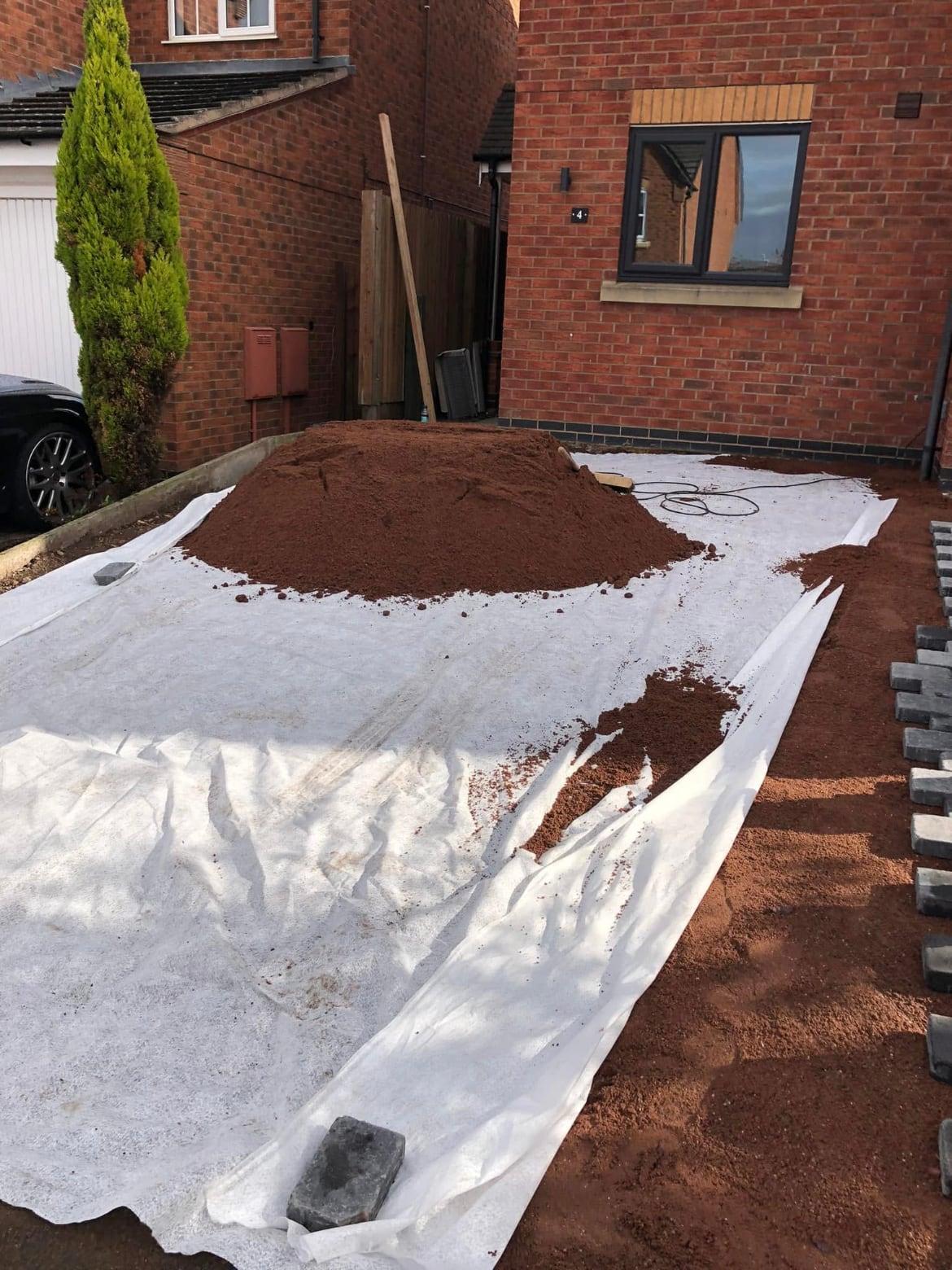 Driveway area being prepared with membrane and a heap of sub-base material