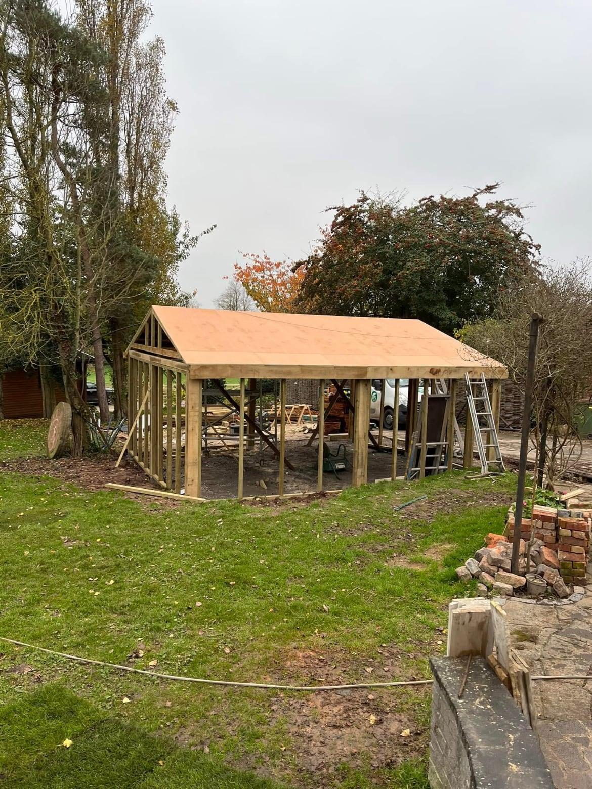Large open timber gazebo frame under construction on a lawn